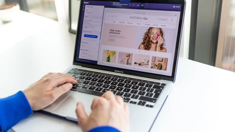 Tangan mengetik laptop yang membuka halaman produk ecommerce untuk optimasi SEO