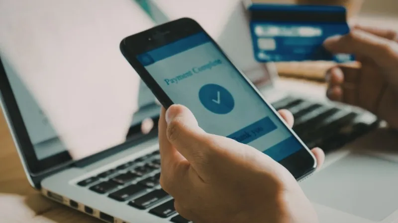 Seseorang melakukan pembayaran contactless menggunakan smartphone di terminal