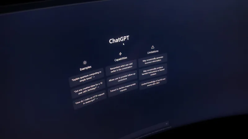 Halaman awal ChatGPT di layar monitor lengkung dengan contoh prompt, kemampuan, dan batasannya