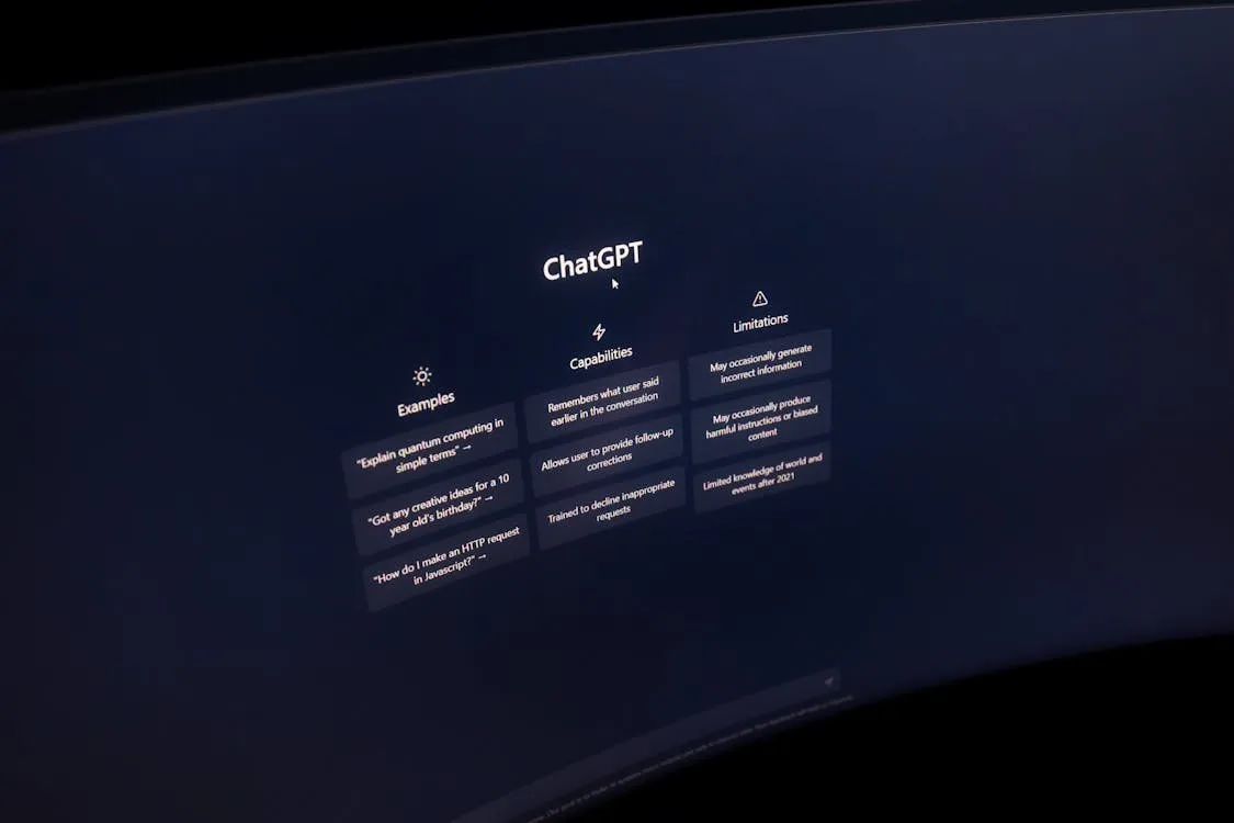 The ChatGPT start screen on a curved monitor, showing example prompts, capabilities and limitations