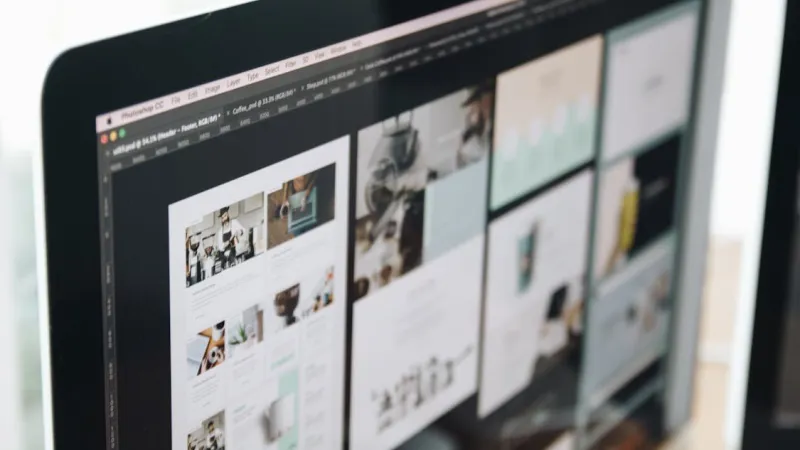 Layar monitor menampilkan beberapa desain halaman website yang sedang dikerjakan di Photoshop