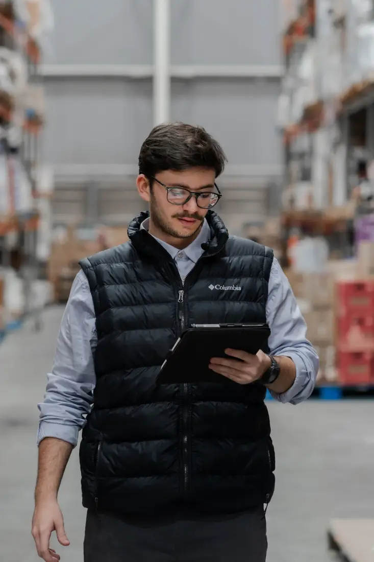 A warehouse worker checking stock data on a tablet