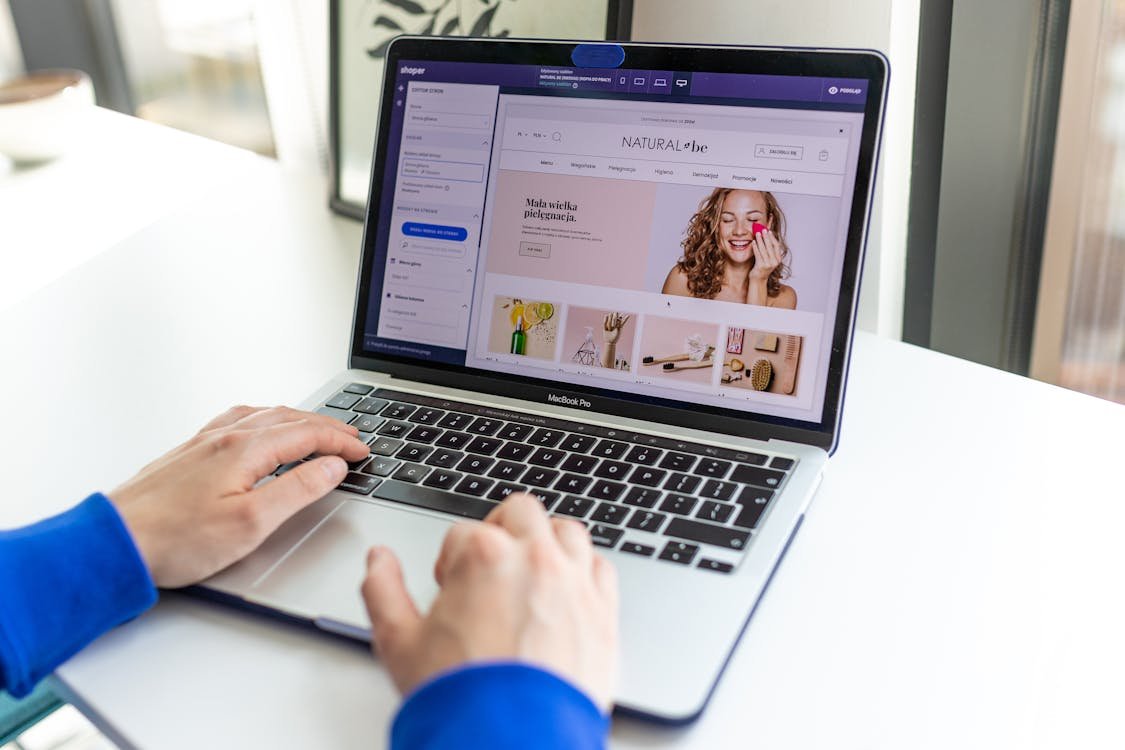 Tangan mengetik laptop yang membuka halaman produk ecommerce untuk optimasi SEO