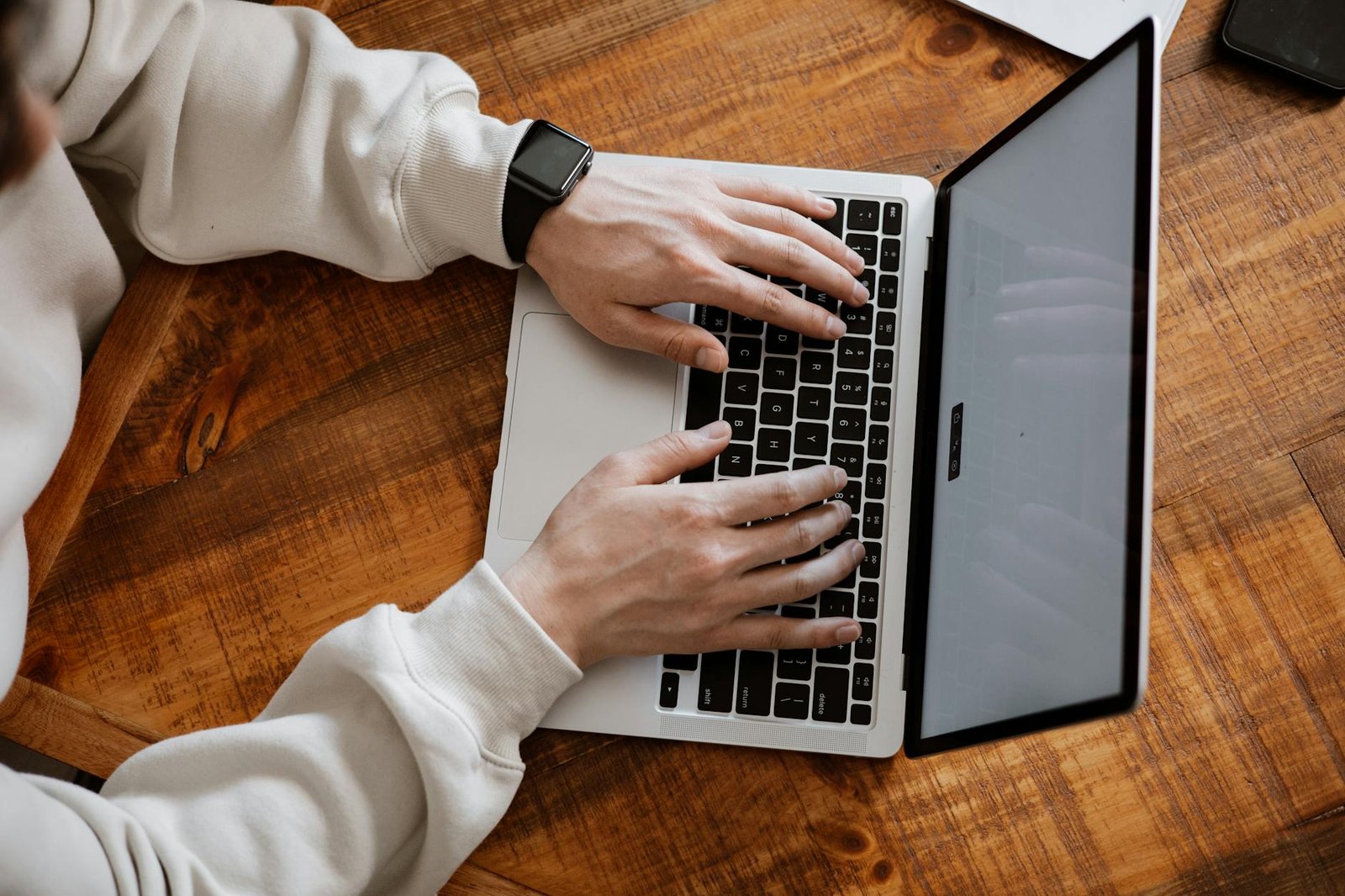 Penulis konten SEO Indonesia mengetik artikel di laptop di meja kerja kayu