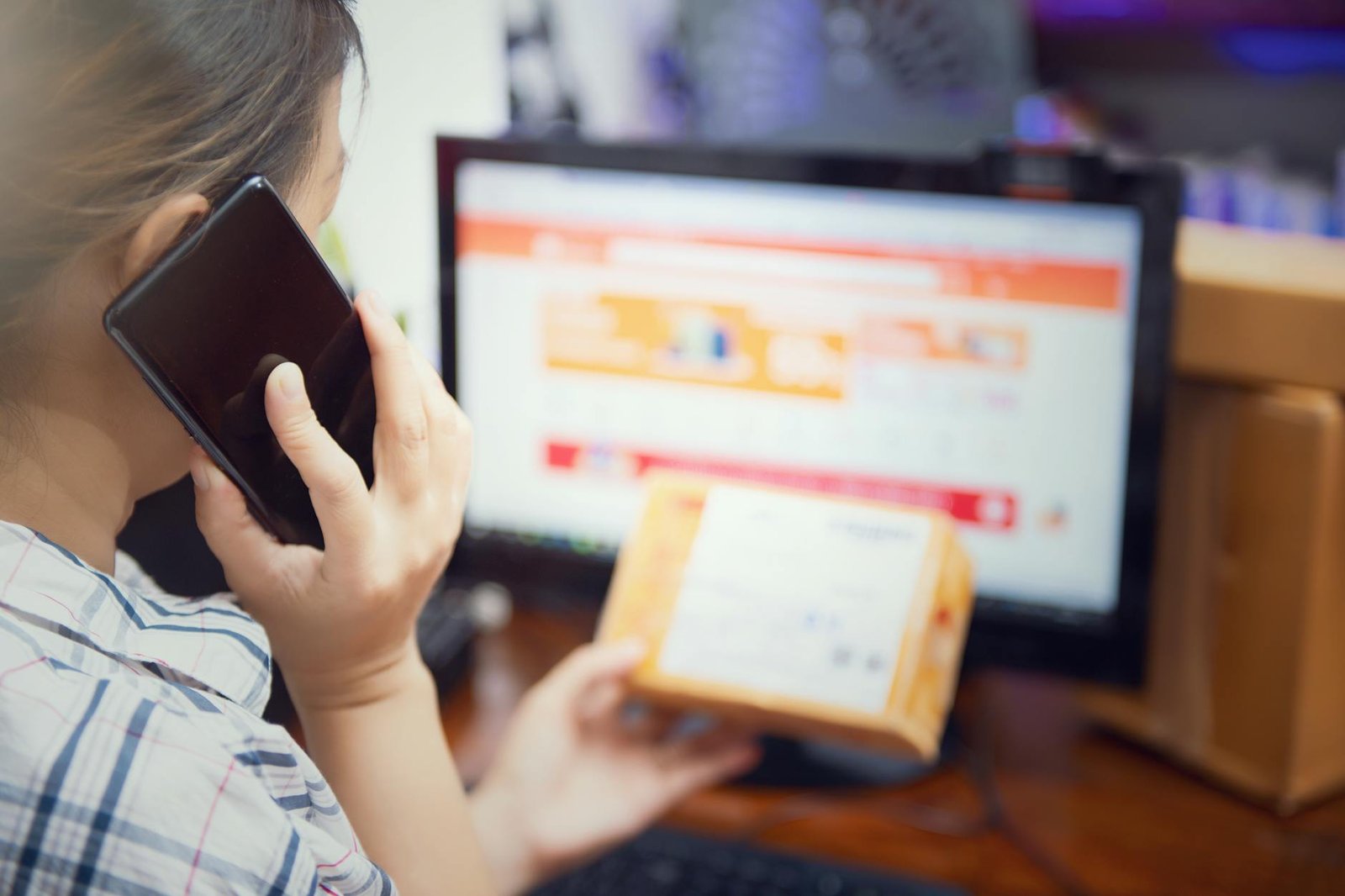 Pemilik toko online wanita Indonesia kelola pesanan paket dari smartphone di rumah
