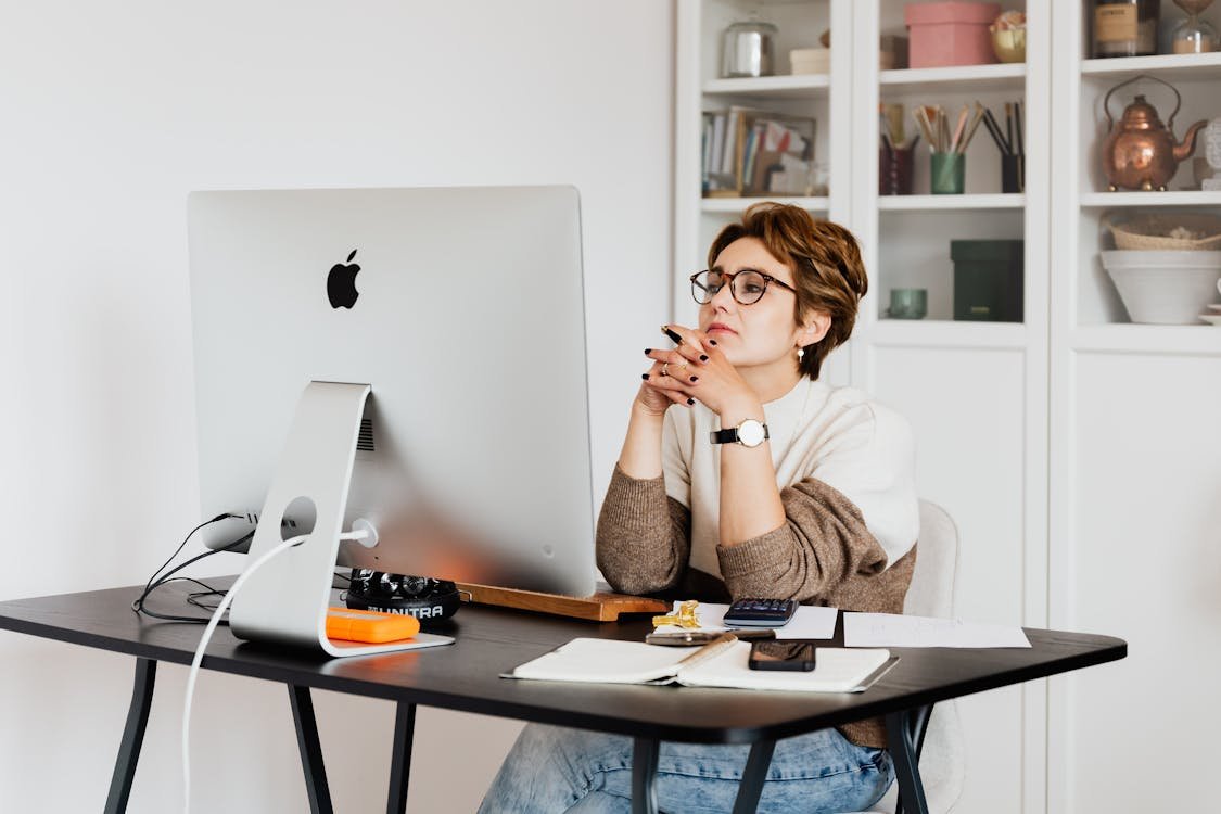 Dua laptop di meja untuk perbandingan platform WordPress dan website custom